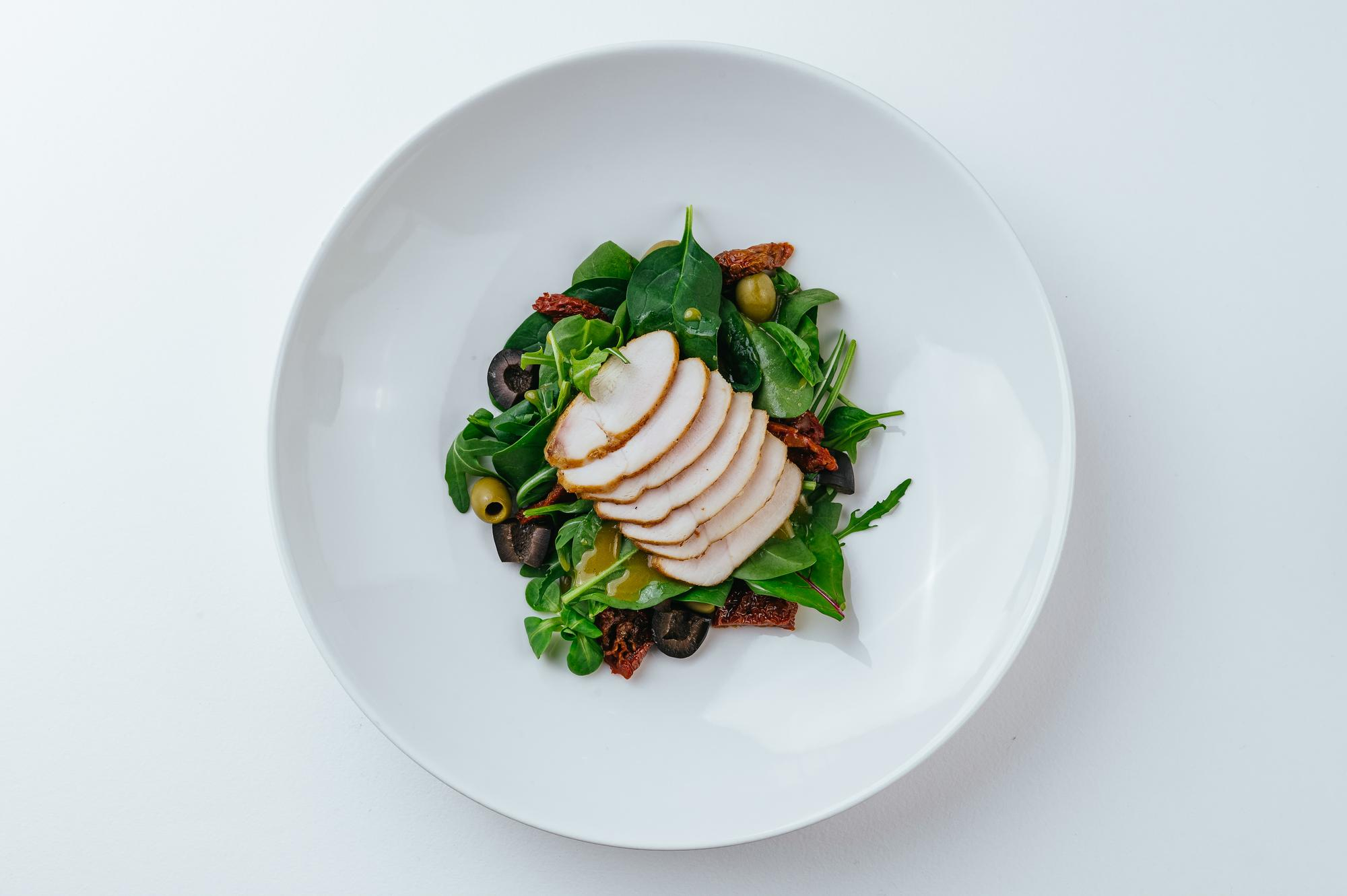 Home cooks learning with fresh ingredients in a bright teaching kitchen